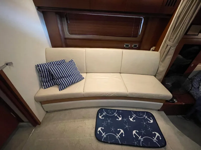 Slide: The Image of Interior of 2007 Sea Ray 38 Sundancer with beige sofa and nautical-themed mat. - 11