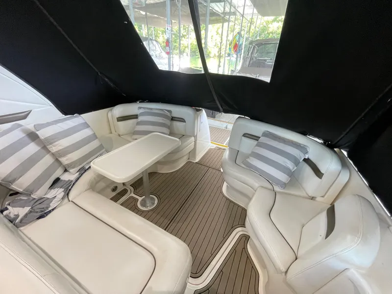 Slide: The Image of Interior seating area of 2007 Sea Ray 38 Sundancer with striped cushions and table. - 6