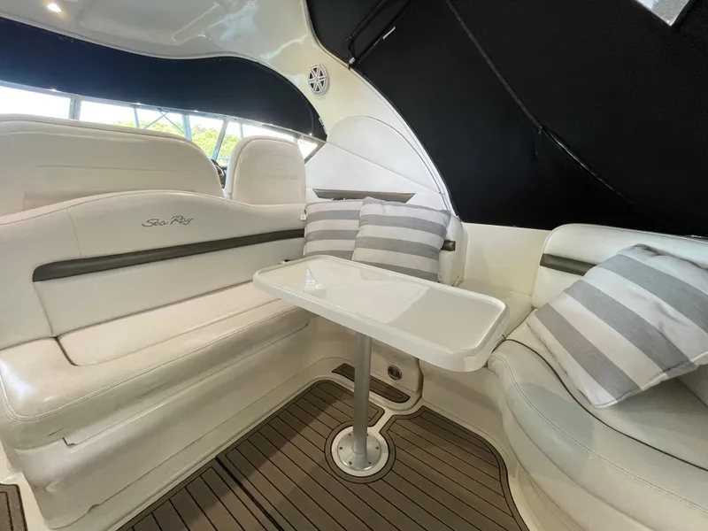 Slide: The Image of Interior seating area of 2007 Sea Ray 38 Sundancer with white leather and striped pillows. - 8