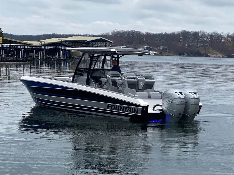 Slide: The Image of 2023 Fountain 34 SC boat on a calm lake with overcast skies. - 4