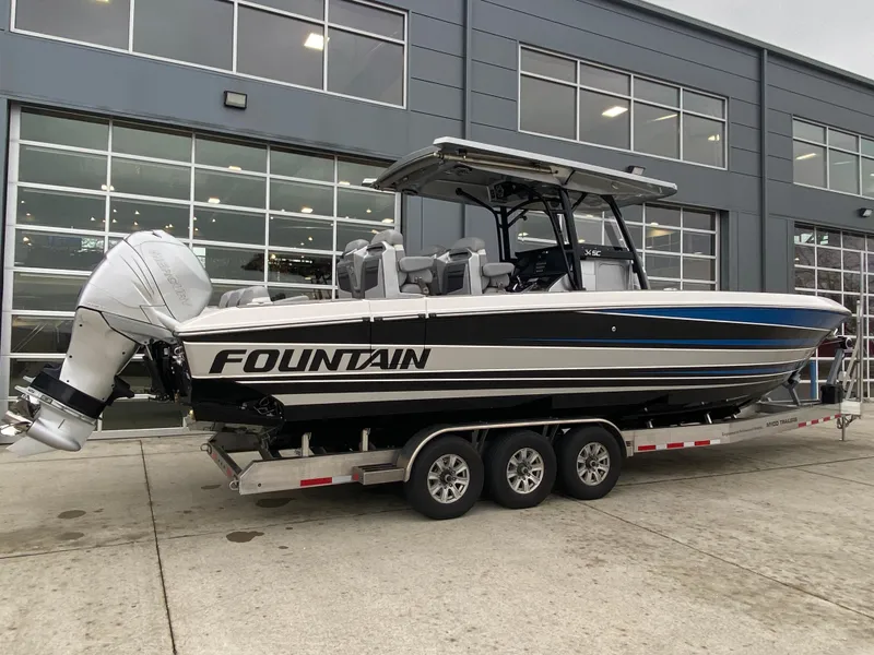 Slide: The Image of 2023 Fountain 34 SC boat on trailer outside a modern building. - 9