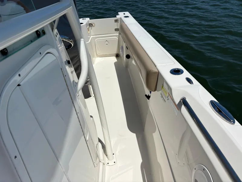 Slide: The Image of 2020 Sailfish 220 CC boat interior with white deck and railing, near water. - 11