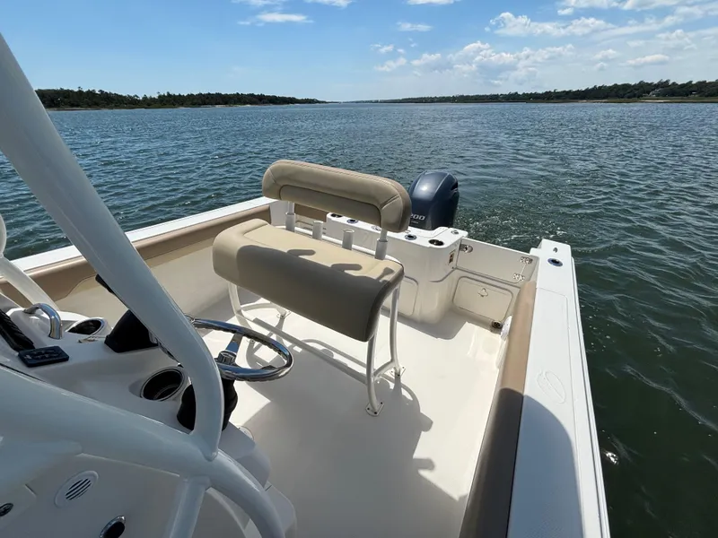 Slide: The Image of 2020 Sailfish 220 CC boat on open water, featuring a comfortable seating area. - 13