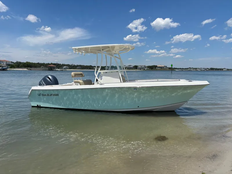 Slide: The Image of 2020 Sailfish 220 CC boat on calm water under a clear blue sky. - 2