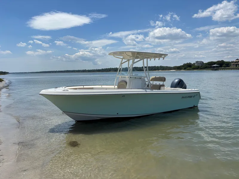 Slide: The Image of 2020 Sailfish 220 CC boat on calm water under a clear sky. - 28