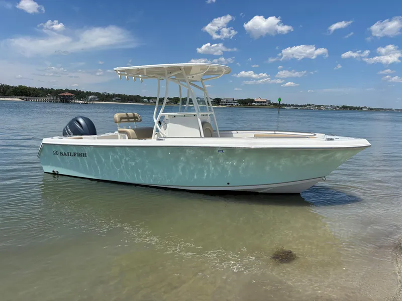 Slide: The Image of 2020 Sailfish 220 CC boat on calm water under a clear blue sky. - 3