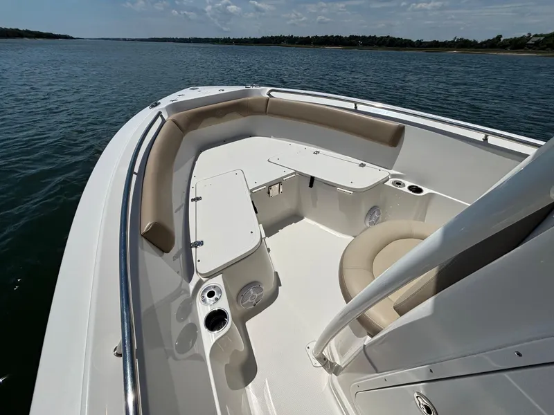 Slide: The Image of 2020 Sailfish 220 CC boat interior with seating and storage, on a calm water body. - 5