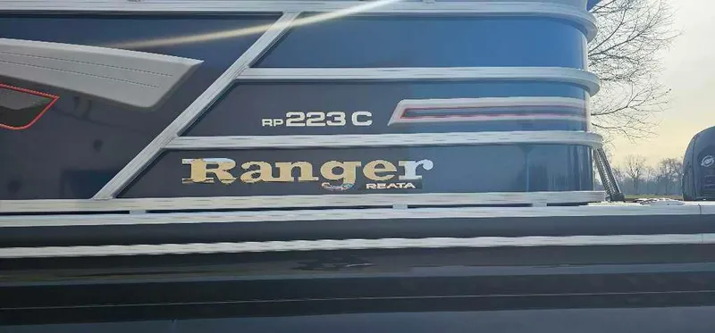 Slide: The Image of 2023 Ranger Reata 223C boat side view with logo and model details. - 2