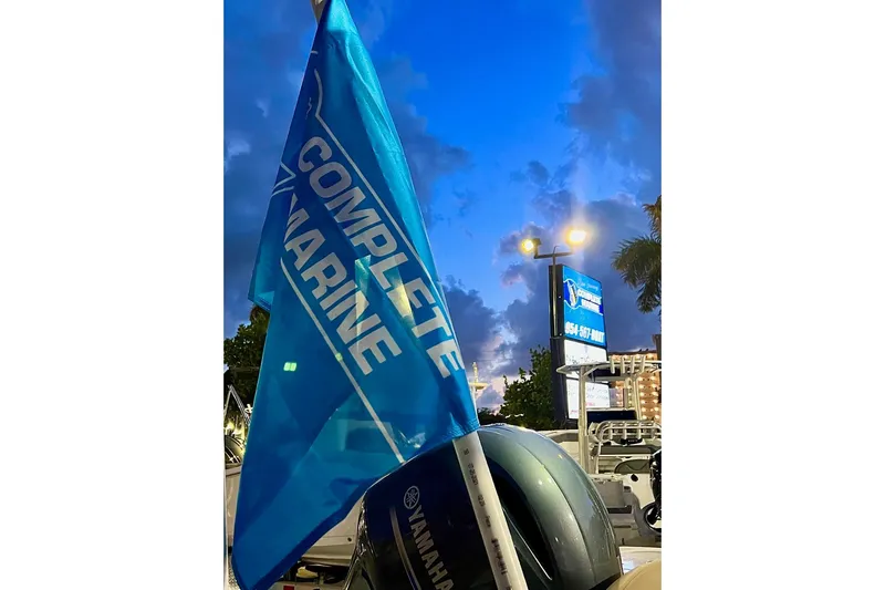 Slide: The Image of Blue "Complete Marine" flag near a 2021 Hurricane SD217 boat at dusk. - 7