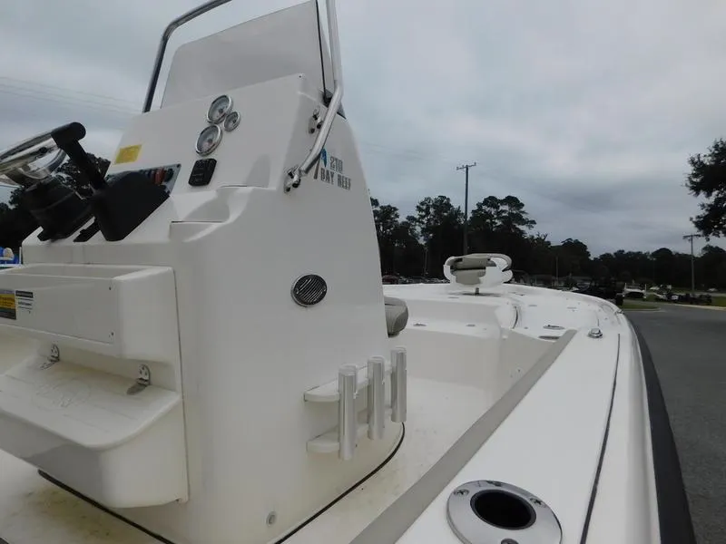Slide: The Image of 2023 Key West 210BR boat console and deck, white exterior, overcast sky. - 10