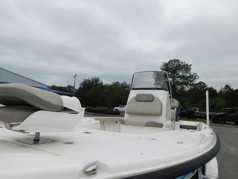 Slide: The Image of 2023 Key West 210BR boat with seating and console, parked outdoors. - 8