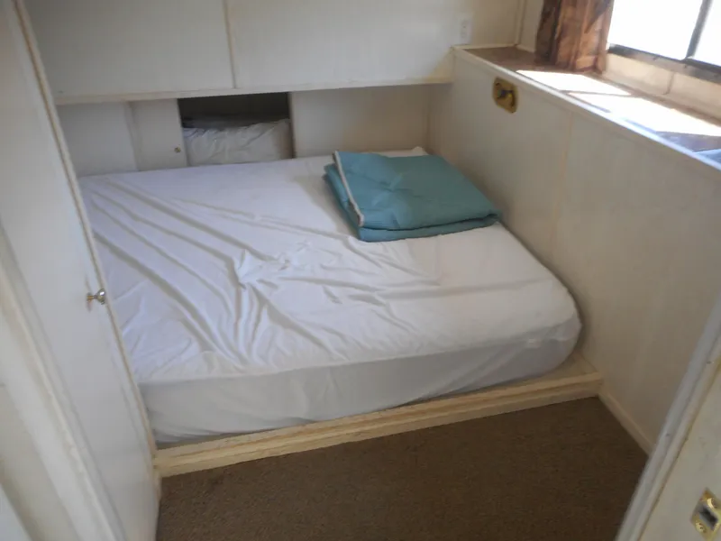 Slide: The Image of Small bedroom with a neatly made bed in a 2000 Stardust Cruisers houseboat. - 19