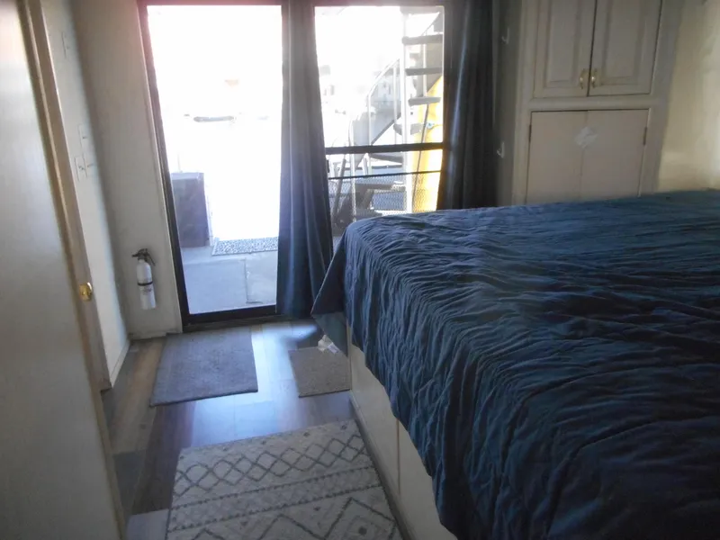 Slide: The Image of Bedroom interior of 2000 Stardust Cruisers Pure Enchantment Share #27 with blue bedding and sliding glass door. - 20