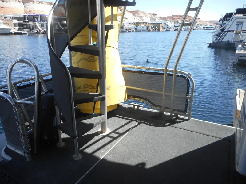 Slide: The Image of Stardust Cruisers 2000 houseboat deck with spiral staircase and water view. - 24