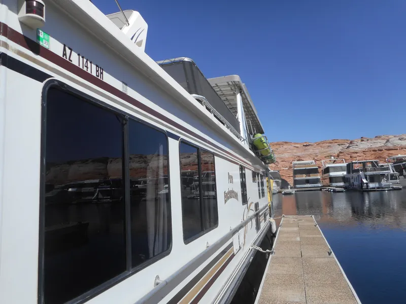 Slide: The Image of Houseboat docked at marina, Stardust Cruisers Pure Enchantment Share #27, 2000 model, clear blue sky. - 3
