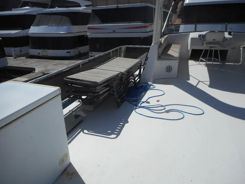 Slide: The Image of 2000 Stardust Cruisers Pure Enchantment Share #27 houseboat deck with stacked chairs and coiled rope. - 33