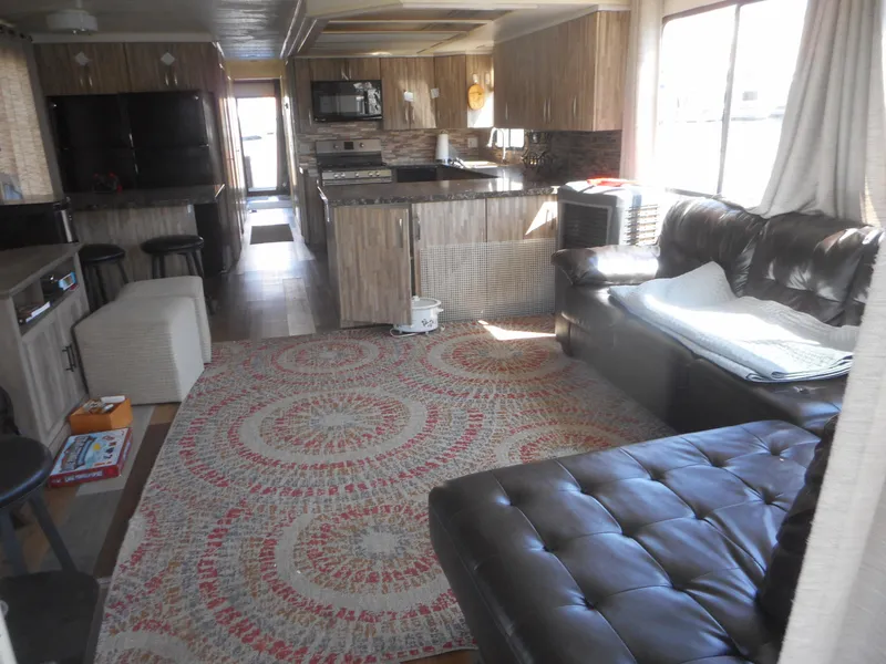 Slide: The Image of Interior of 2000 Stardust Cruisers houseboat with modern kitchen, leather seating, and patterned rug. - 5