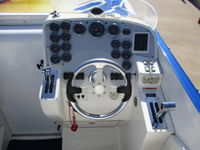 Slide: The Image of 2002 Hustler 388 SLINGSHOT boat dashboard with steering wheel and gauges. - 12