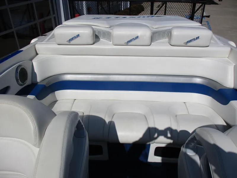 Slide: The Image of 2002 Hustler 388 SLINGSHOT boat interior with white and blue seating. - 16