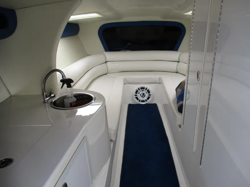 Slide: The Image of Interior of a 2002 Hustler 388 SLINGSHOT boat with white seating and blue carpet. - 20