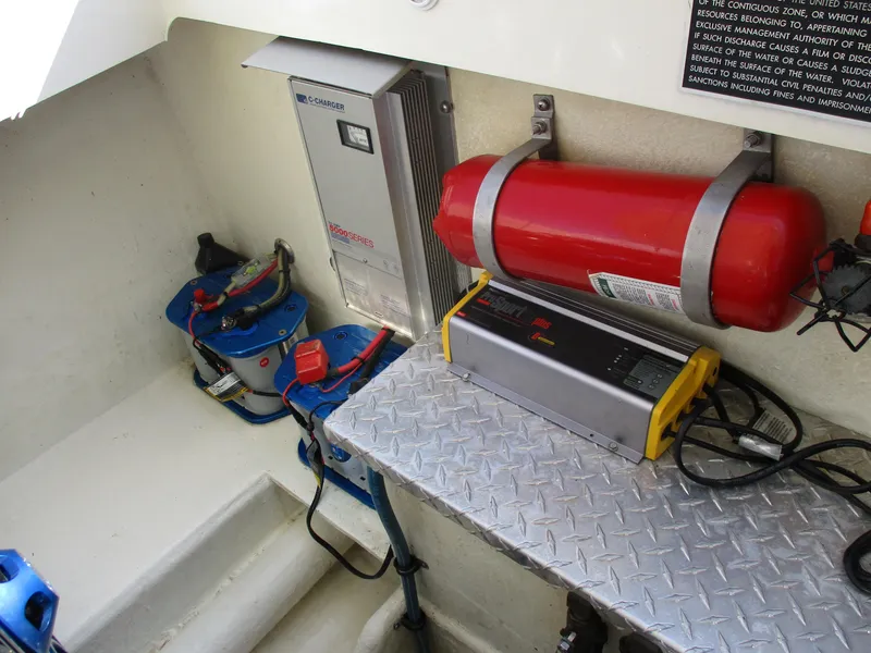 Slide: The Image of 2002 Hustler 388 SLINGSHOT engine compartment with battery, fire extinguisher, and electrical components. - 29