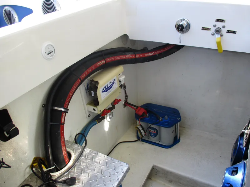 Slide: The Image of 2002 Hustler 388 SLINGSHOT boat engine compartment with wiring and battery. - 30