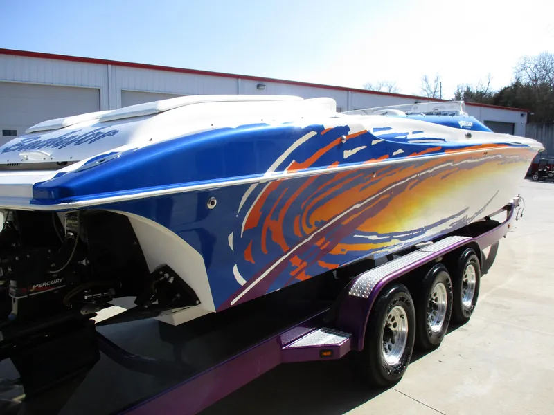 Slide: The Image of 2002 Hustler 388 SLINGSHOT speedboat with vibrant custom paint on a triple-axle trailer. - 5