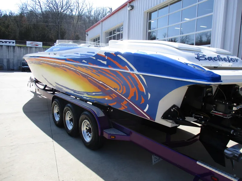 Slide: The Image of 2002 Hustler 388 SLINGSHOT speedboat with vibrant custom paint on trailer. - 6