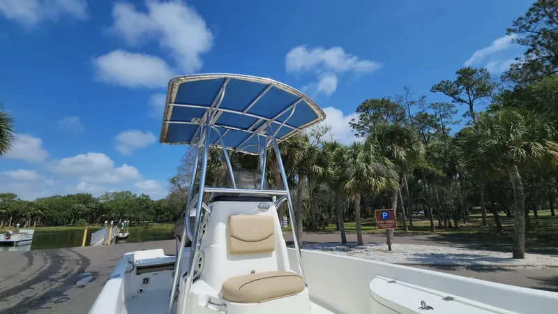Slide: The Image of 2020 NauticStar 2140 Sport boat with T-top in a sunny park setting. - 21