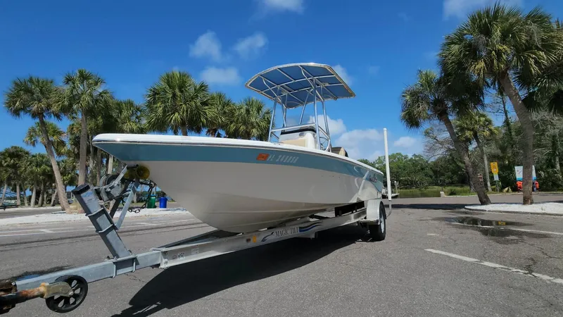 Slide: The Image of 2020 NauticStar 2140 Sport boat on trailer, parked near palm trees. - 43