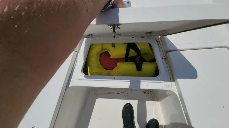 Slide: The Image of Person opening storage compartment on 2020 NauticStar 2140 Sport boat. - 6