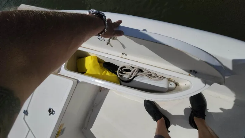 Slide: The Image of 2020 NauticStar 2140 Sport boat storage compartment with safety gear and rope. - 7