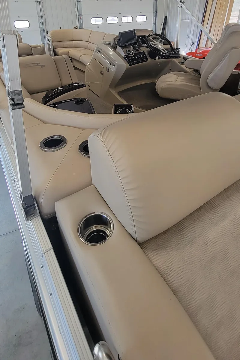 Slide: The Image of 2011 Bennington 2575 RCW 3 I/O boat interior with beige seating and cup holders. - 14