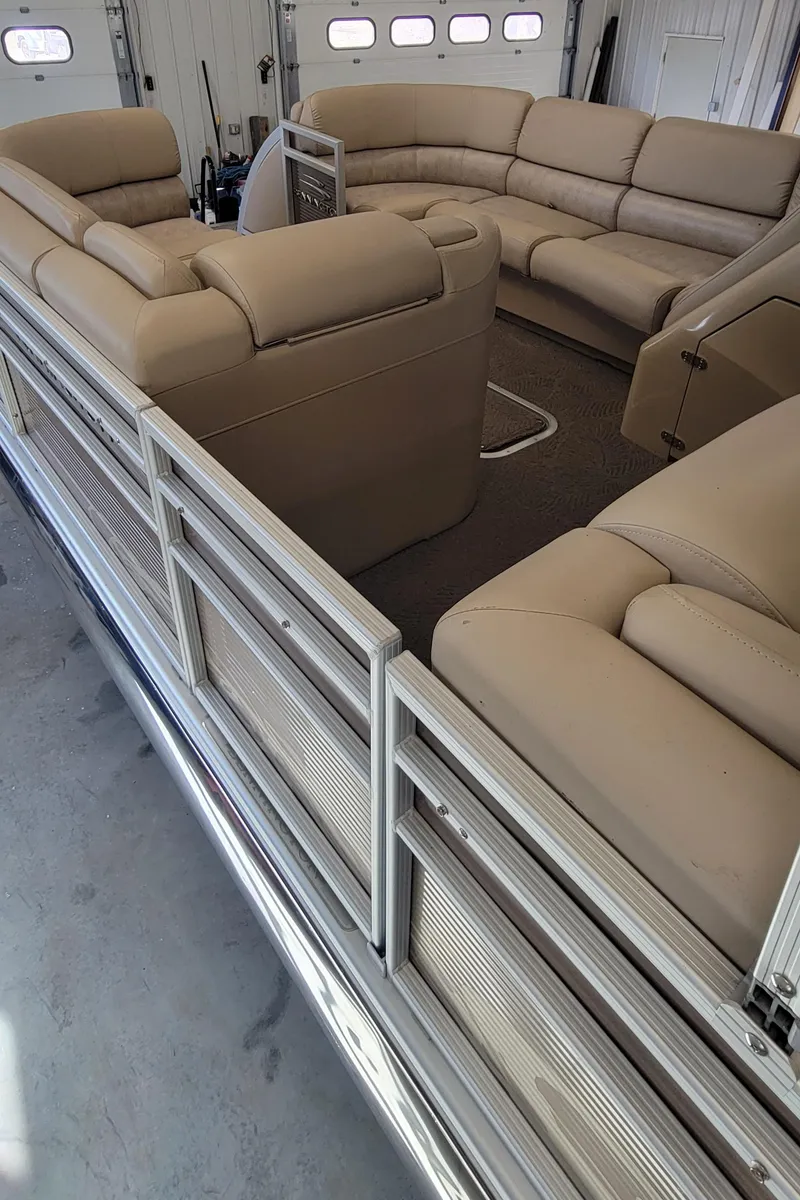 Slide: The Image of 2011 Bennington 2575 RCW 3 I/O pontoon boat with beige seating in a garage. - 15