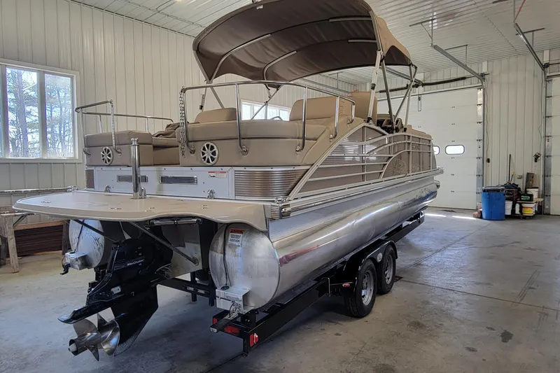 Slide: The Image of 2011 Bennington 2575 RCW 3 I/O pontoon boat in a garage, rear view. - 2