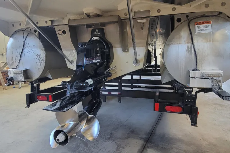 Slide: The Image of 2011 Bennington 2575 RCW 3 I/O boat with dual propellers in a garage. - 3