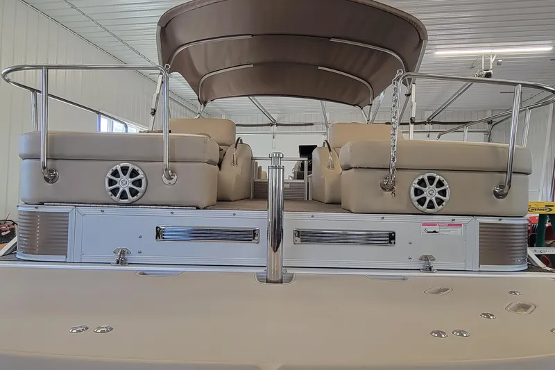 Slide: The Image of 2011 Bennington 2575 RCW 3 I/O pontoon boat with beige seating and canopy in a garage. - 5