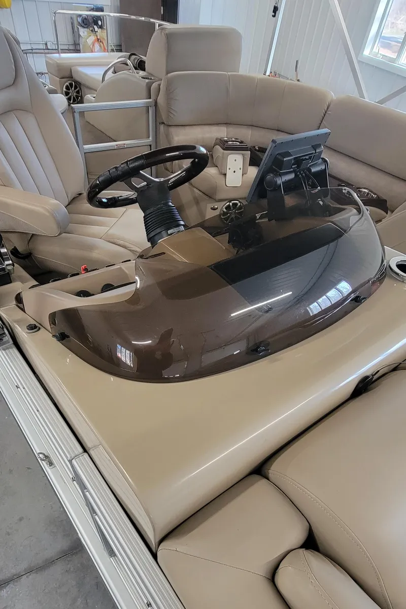 Slide: The Image of 2011 Bennington 2575 RCW 3 I/O boat interior with steering wheel and beige seating. - 6