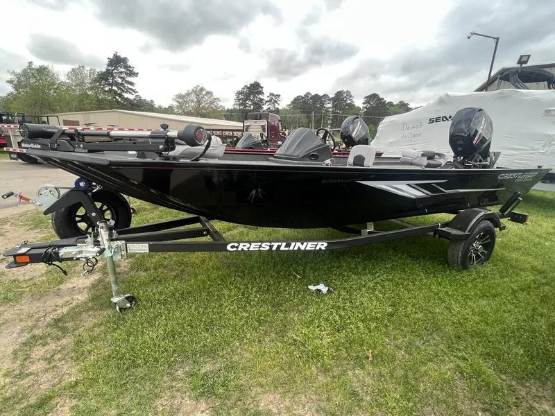 The Image of 2023 Crestliner 1700 Storm fishing boat on trailer, black exterior, parked on grass. - 1