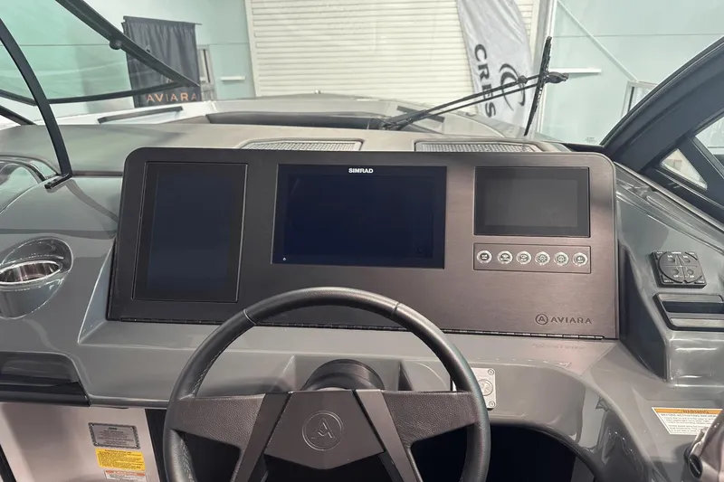 Slide: The Image of 2023 Aviara AV32 boat dashboard with modern digital displays and steering wheel. - 24