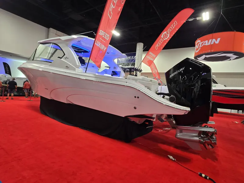 The Image of 2025 Fountain 39 DX boat displayed indoors on red carpet with promotional banners. - 0