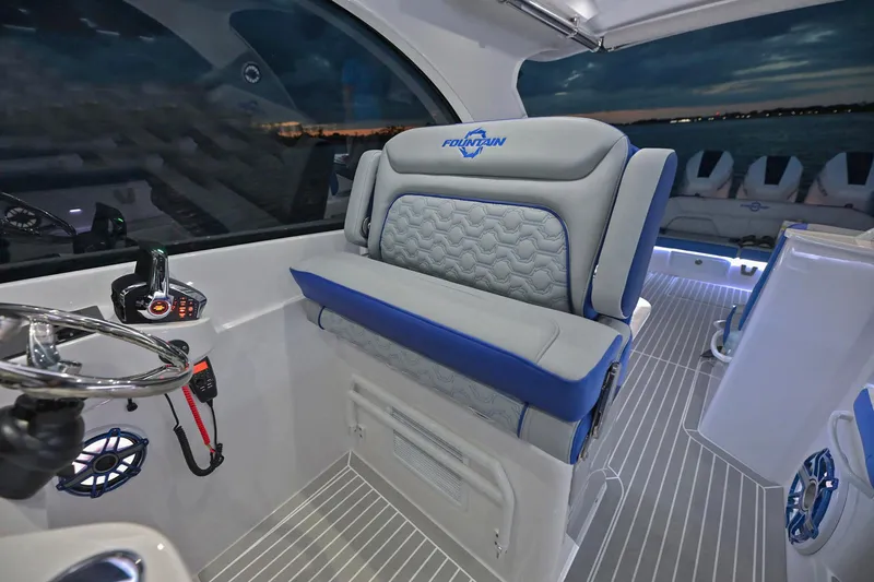 Slide: The Image of 2025 Fountain 39 DX boat interior with steering wheel and cushioned seating. - 10
