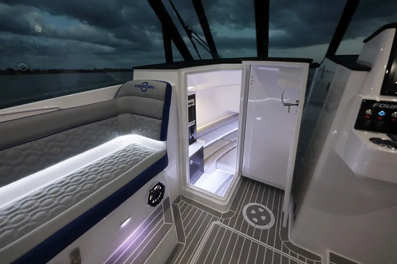 Slide: The Image of Interior of 2025 Fountain 39 DX boat with open refrigerator and cushioned seating. - 6