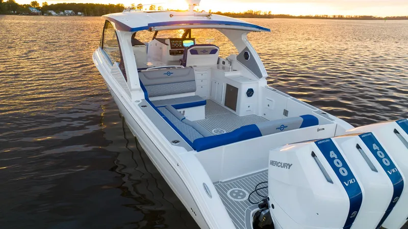 Slide: The Image of 2025 Fountain 39 DX boat with triple Mercury 400 engines on a serene lake at sunset. - 9