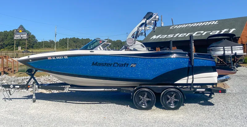 Slide: The Image of 2021 MasterCraft XT22 boat on trailer, parked outside dealership. - 1