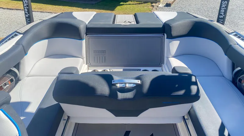 Slide: The Image of 2021 MasterCraft XT22 boat interior with cushioned seating and storage compartment. - 11