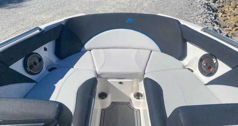 Slide: The Image of 2021 MasterCraft XT22 boat interior with sleek seating and built-in speakers. - 16