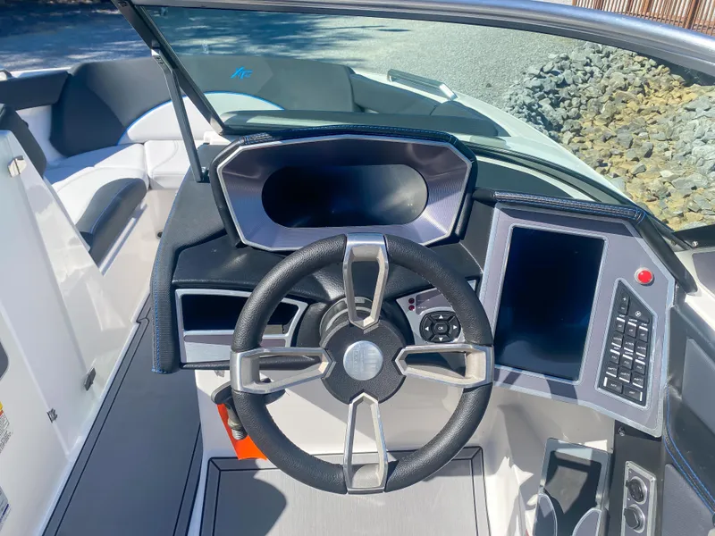 Slide: The Image of 2021 MasterCraft XT22 boat dashboard with steering wheel and digital display. - 17
