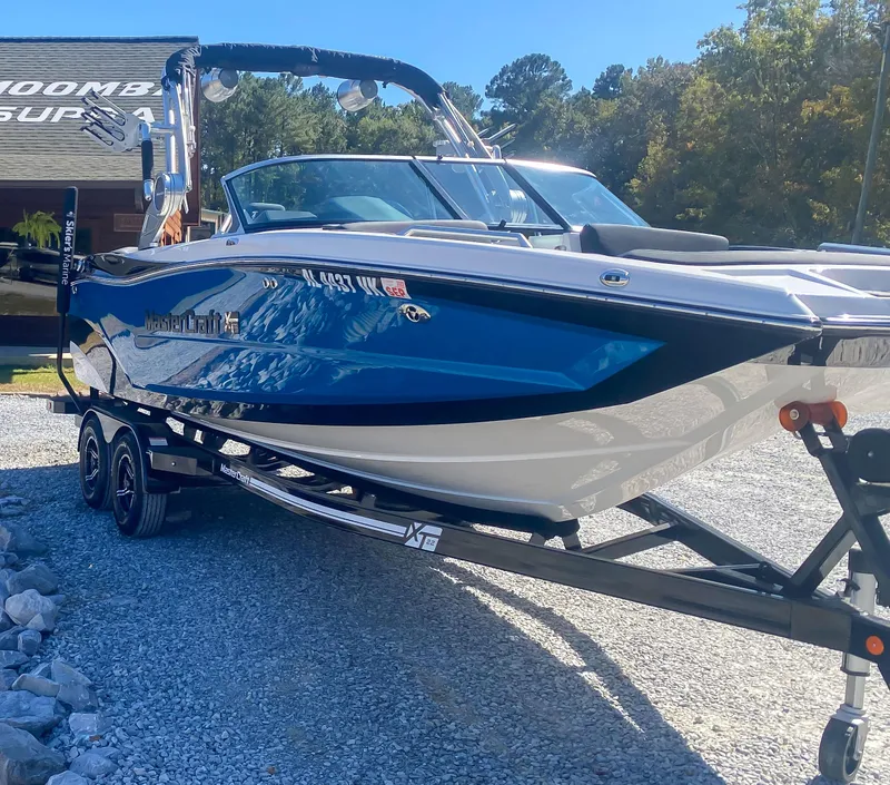 Slide: The Image of 2021 MasterCraft XT22 boat on trailer, parked outdoors. - 3