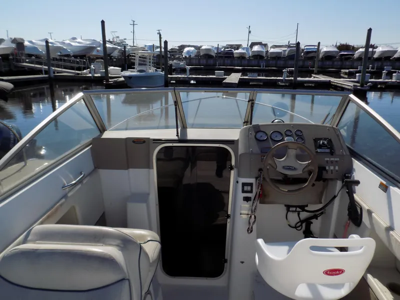 Slide: The Image of 2001 Bayliner 2252 Ciera Classic boat interior at marina, featuring helm and seating. - 2